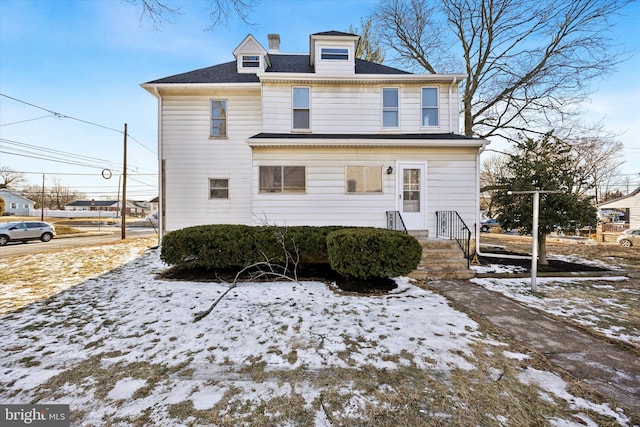 view of snow covered back of property