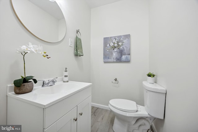 bathroom with hardwood / wood-style flooring, vanity, and toilet