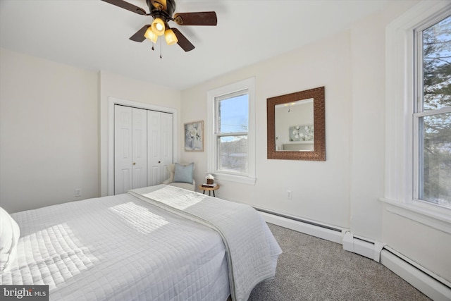 bedroom with multiple windows, a baseboard radiator, carpet floors, and a closet