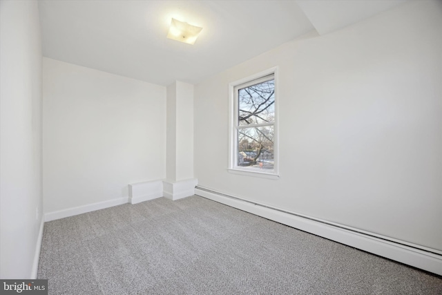 carpeted spare room featuring a baseboard heating unit