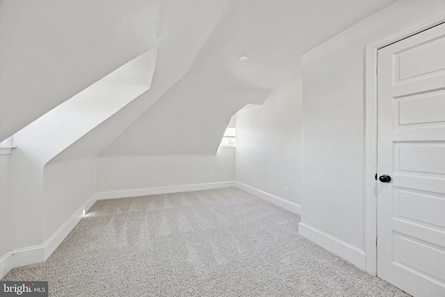 bonus room with light colored carpet and lofted ceiling