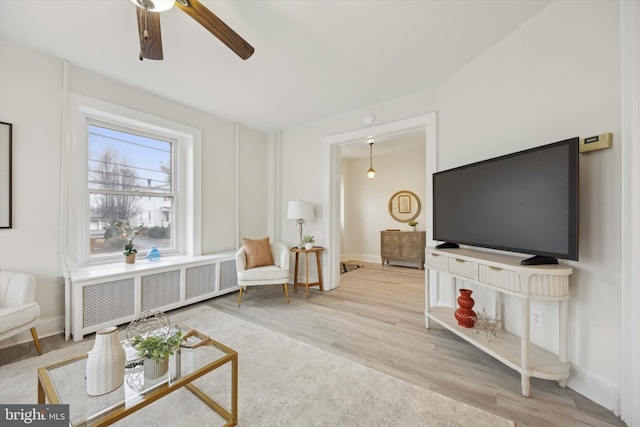 living room with ceiling fan, radiator heating unit, and wood-type flooring