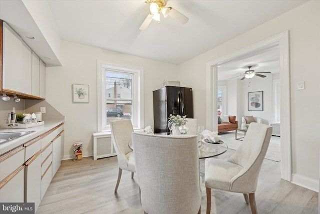 dining space featuring ceiling fan and light wood-type flooring