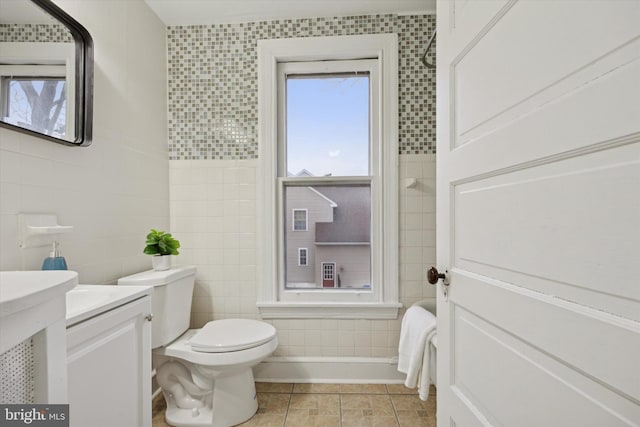 bathroom featuring vanity, toilet, tile patterned flooring, and tile walls