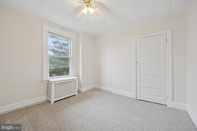 carpeted spare room with ceiling fan