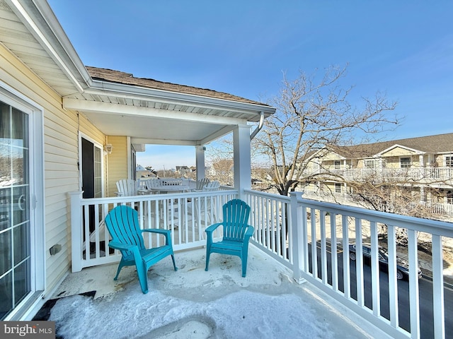 view of snow covered back of property