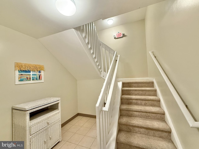 staircase with vaulted ceiling and tile patterned flooring