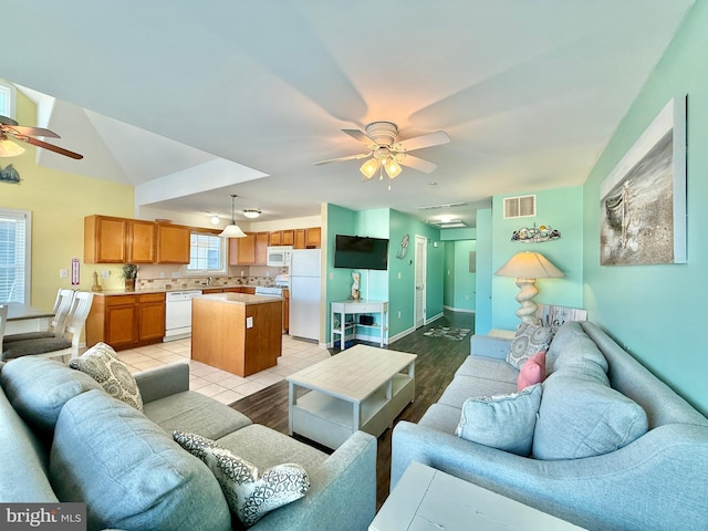 tiled living room with ceiling fan