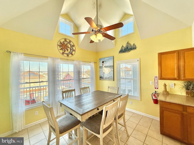 dining room with ceiling fan, high vaulted ceiling, and light tile patterned floors