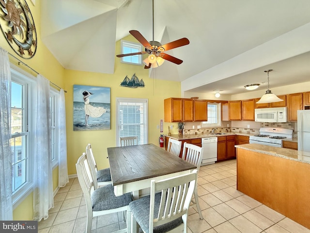 dining room with ceiling fan, high vaulted ceiling, sink, and light tile patterned floors