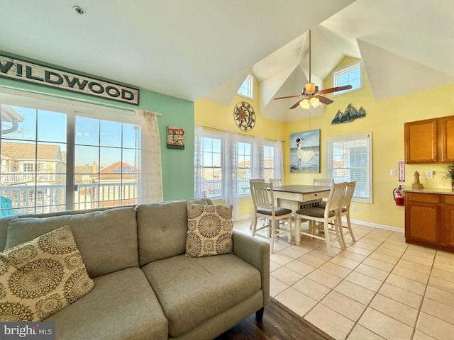 living room featuring light tile patterned flooring, plenty of natural light, high vaulted ceiling, and ceiling fan