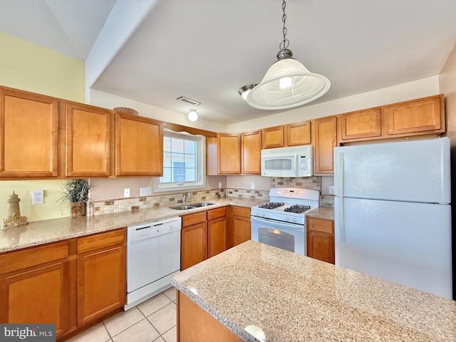 kitchen with sink, hanging light fixtures, light tile patterned floors, light stone countertops, and white appliances