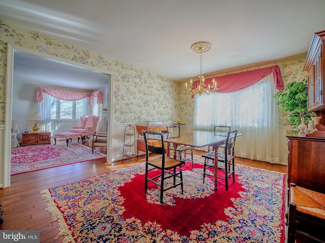 dining area with hardwood / wood-style floors and a chandelier