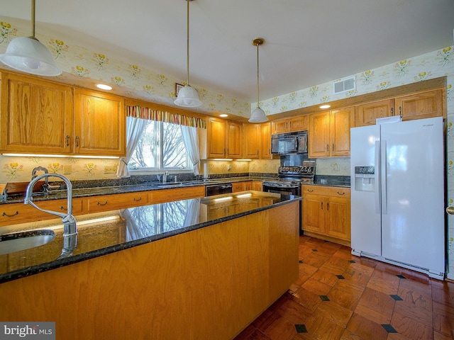 kitchen with dark parquet floors, sink, dark stone countertops, hanging light fixtures, and black appliances