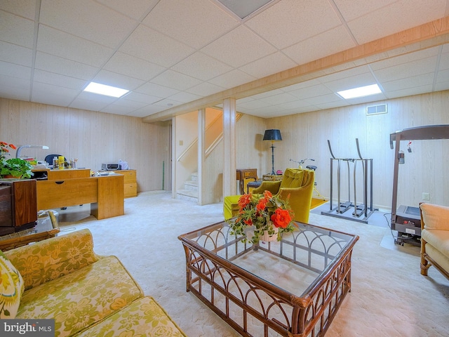 carpeted living room featuring a drop ceiling