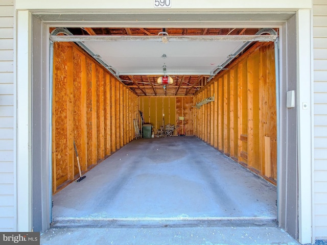 garage with a garage door opener and wooden walls