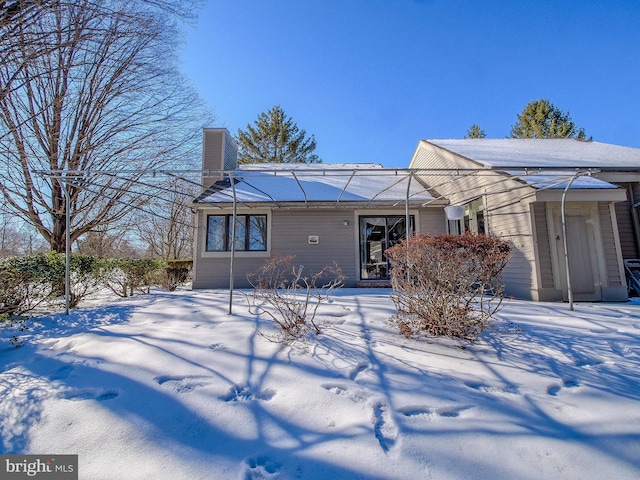 view of snow covered back of property