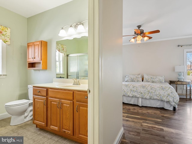 bathroom with hardwood / wood-style flooring, ceiling fan, vanity, and toilet