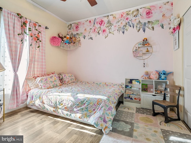 bedroom featuring ornamental molding, ceiling fan, and light wood-type flooring