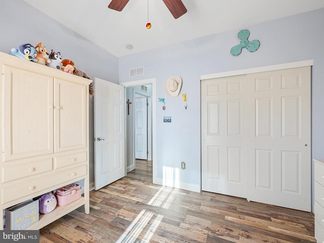 unfurnished bedroom with wood-type flooring, ceiling fan, and a closet