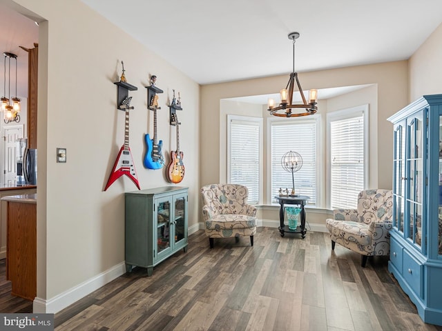 sitting room with dark wood-type flooring and an inviting chandelier