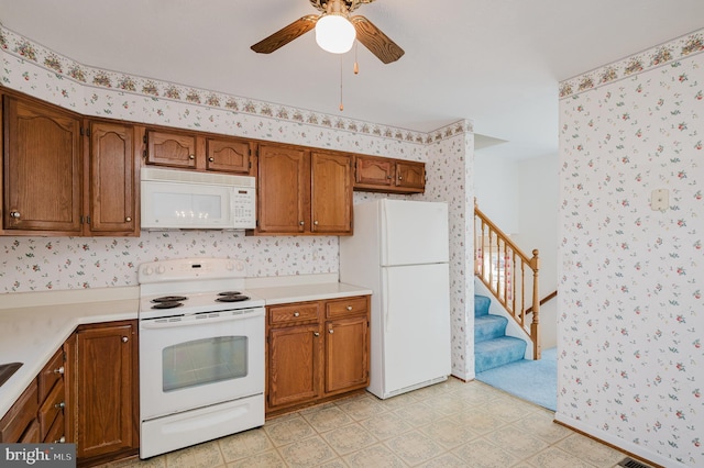 kitchen with brown cabinetry, white appliances, light countertops, and wallpapered walls