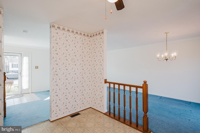 spare room with visible vents, carpet floors, baseboards, and crown molding