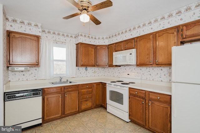 kitchen with wallpapered walls, light floors, brown cabinetry, white appliances, and a sink