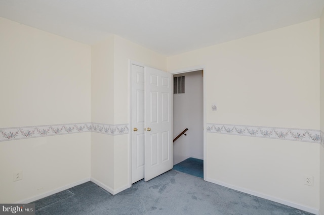 empty room with visible vents, baseboards, and carpet