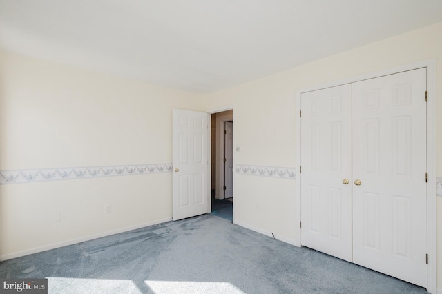 unfurnished bedroom featuring baseboards, a closet, and carpet floors