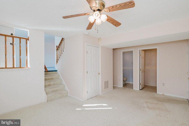 interior space featuring visible vents, baseboards, a ceiling fan, and stairs