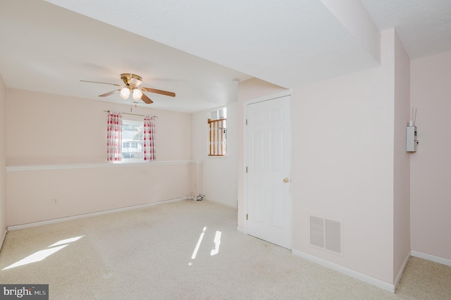 spare room with visible vents, baseboards, carpet floors, and a ceiling fan