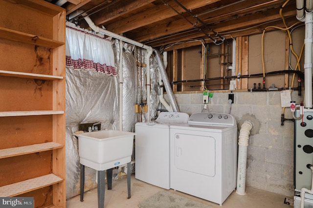 clothes washing area featuring laundry area, independent washer and dryer, and a sink