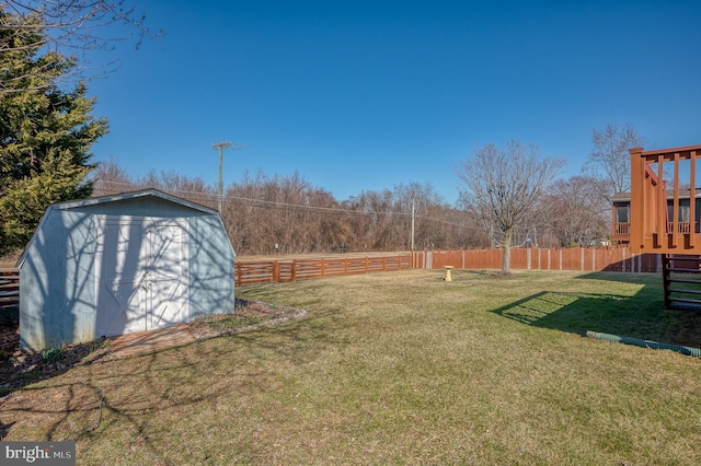 view of yard with a storage shed, an outdoor structure, and fence