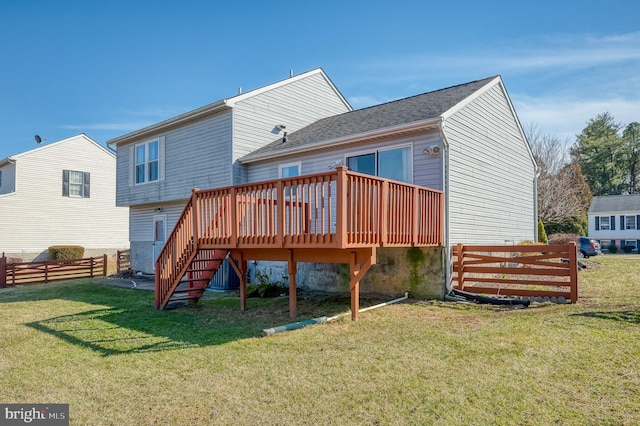 rear view of house with a yard, a deck, stairs, and fence