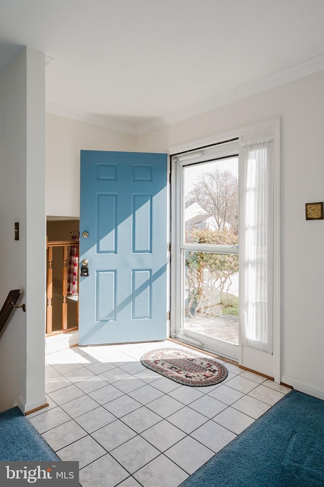 foyer featuring light tile patterned floors, baseboards, and ornamental molding