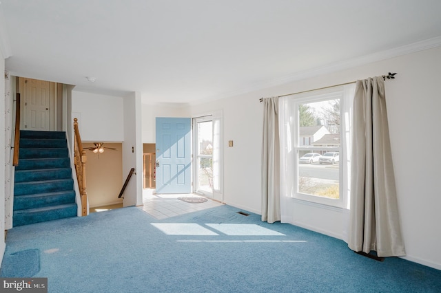 unfurnished living room featuring carpet flooring, stairs, baseboards, and ornamental molding