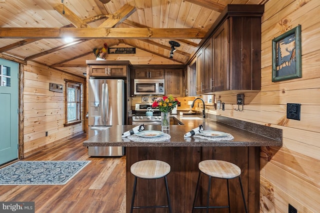 kitchen featuring appliances with stainless steel finishes, wooden walls, sink, kitchen peninsula, and wooden ceiling