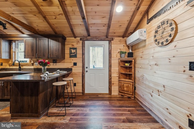 kitchen featuring dark hardwood / wood-style flooring, a wall unit AC, a breakfast bar, and wooden ceiling