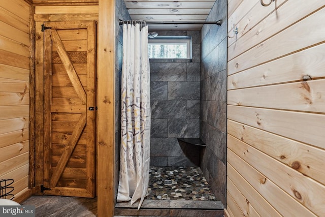 bathroom featuring wooden walls and a shower with shower curtain