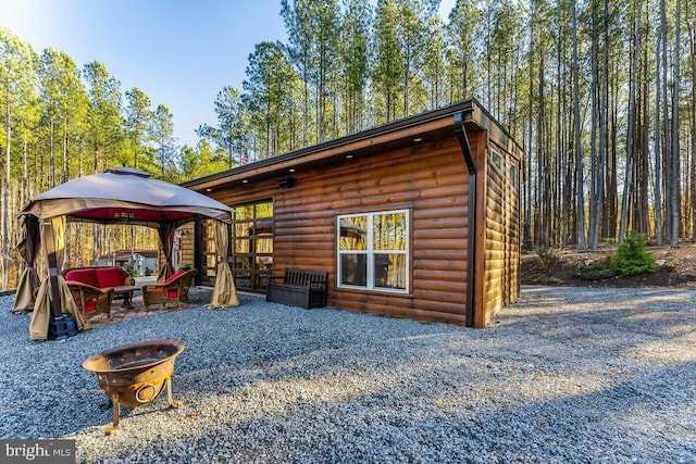 exterior space featuring a gazebo and a fire pit