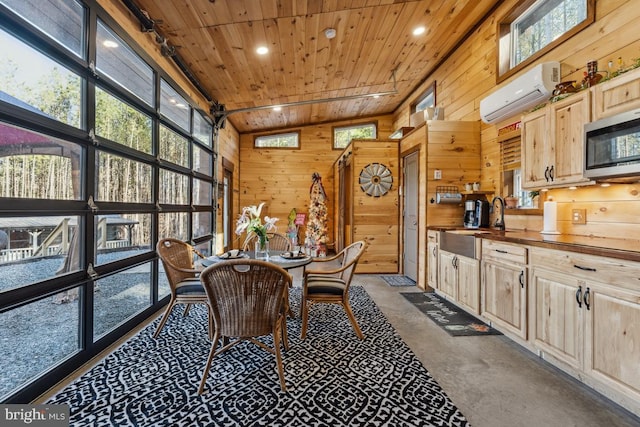 dining area featuring wood ceiling, an AC wall unit, sink, and wood walls