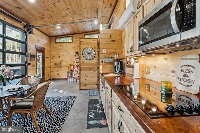 kitchen with light brown cabinetry, wood walls, wooden counters, wooden ceiling, and black electric cooktop