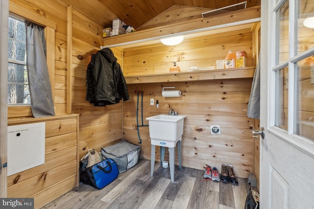 mudroom with lofted ceiling, hardwood / wood-style floors, and wooden walls