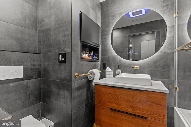 bathroom with vanity, toilet, and tile walls