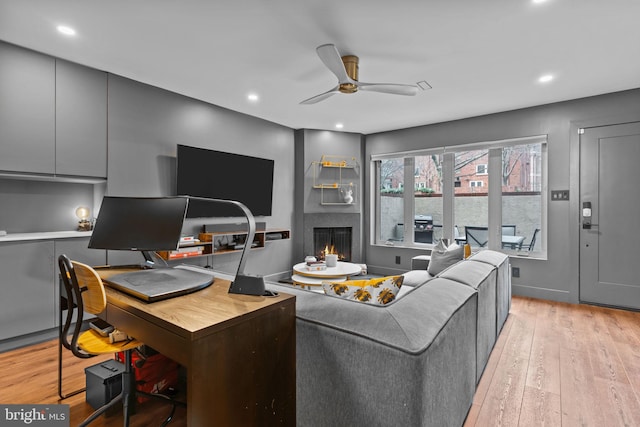 living room with light hardwood / wood-style floors and ceiling fan