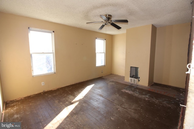 unfurnished living room with ceiling fan, dark hardwood / wood-style floors, and a textured ceiling