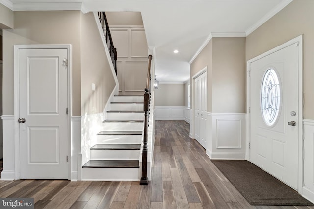 foyer entrance with crown molding and hardwood / wood-style floors