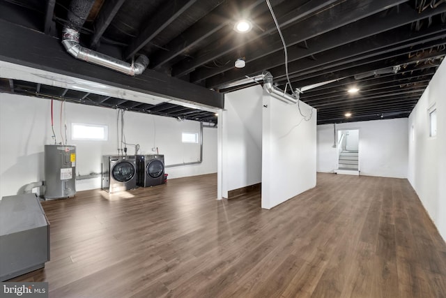 basement with wood-type flooring, electric water heater, and washing machine and dryer