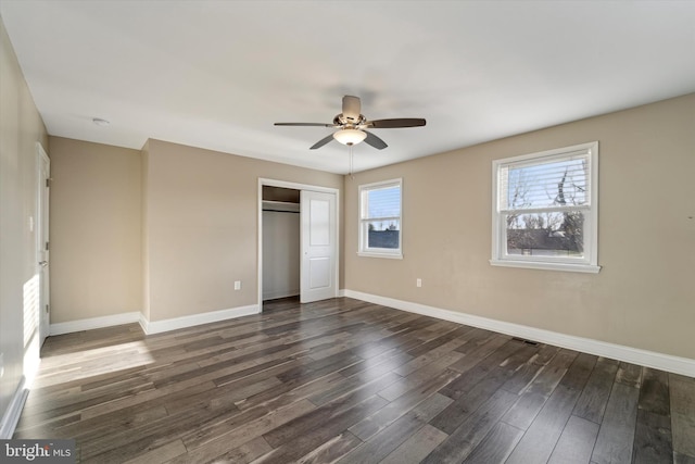 unfurnished bedroom featuring dark hardwood / wood-style floors, ceiling fan, and a closet